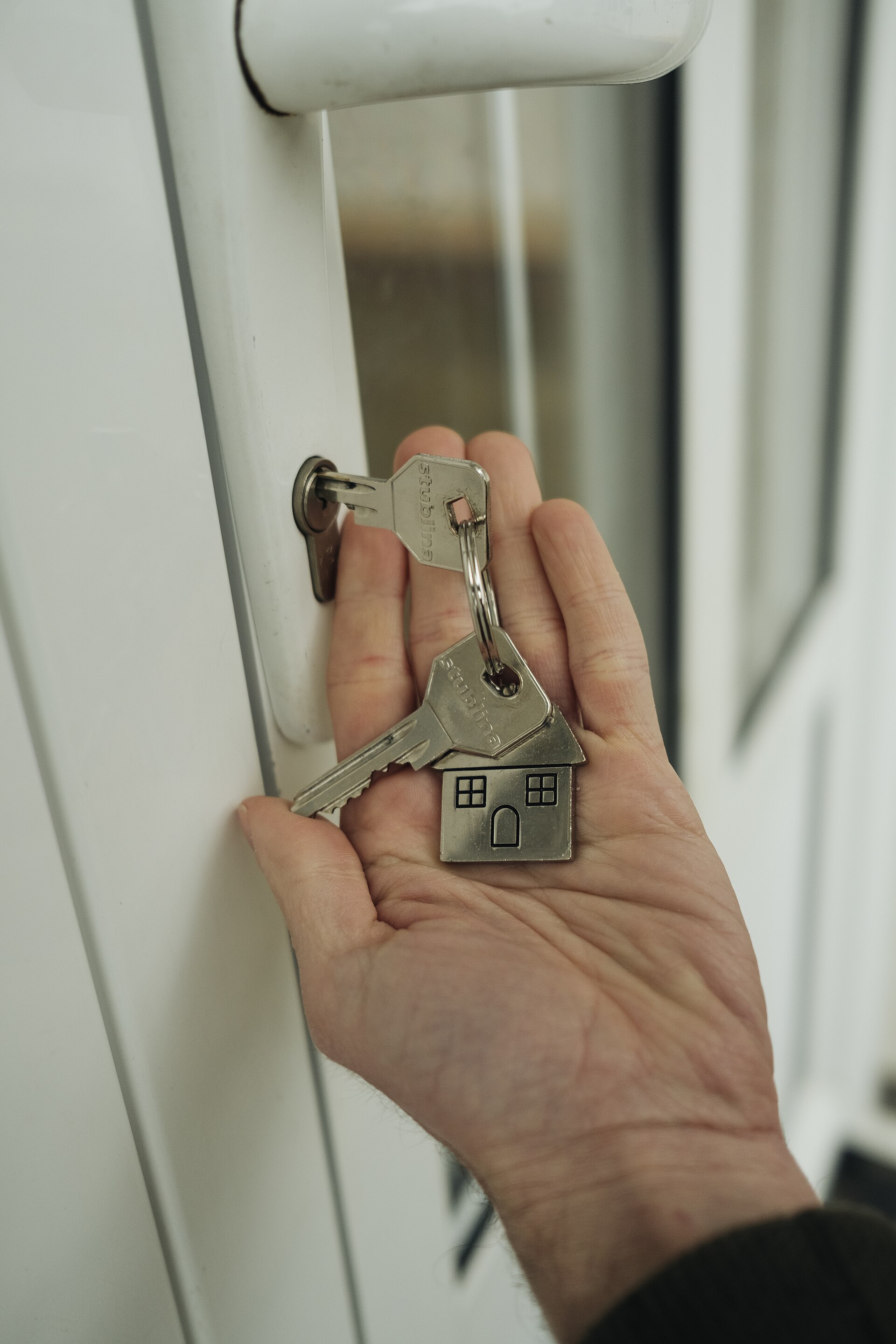 Main tenant des clés près d’une serrure de porte